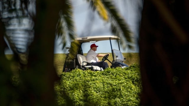 Trump im Golfcaddy, fotografiert aus der Ferne. Trump im Golfcaddy, fotografiert aus der Ferne.