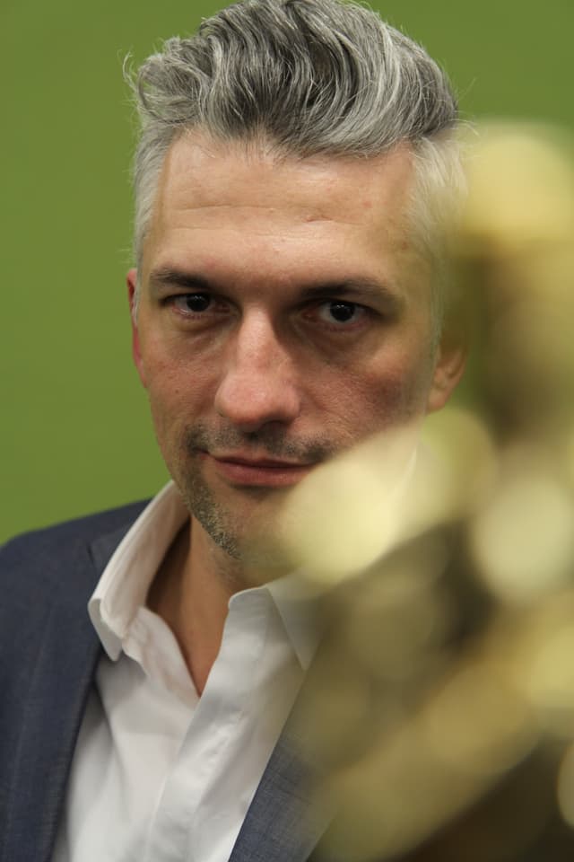 Attraktiver Mann mit graumeliertem Haar in die Kamera blickend und entspannt lächelnd. Attraktiver Mann mit graumeliertem Haar in die Kamera blickend und entspannt lächelnd.