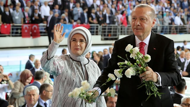 Erdogan und Frau mit Kopftuch vor Menge. Er hat Blumen in der Hand. Erdogan und Frau mit Kopftuch vor Menge. Er hat Blumen in der Hand.