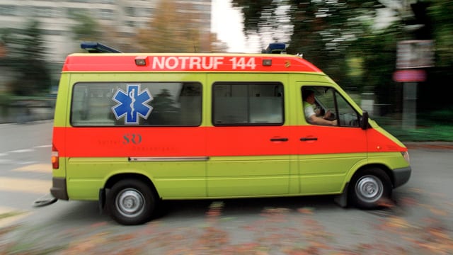 Ein Ambulanzfahrzeug rast über einen Fussgängerstreifen Ein Ambulanzfahrzeug rast über einen Fussgängerstreifen