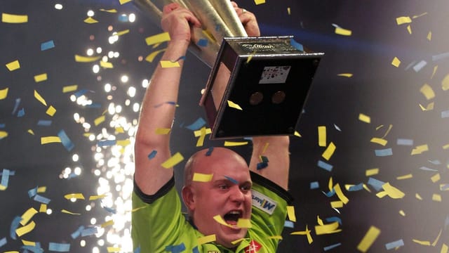 Van Gerwen stemmt die Trophäe in die Höhe. Van Gerwen stemmt die Trophäe in die Höhe.