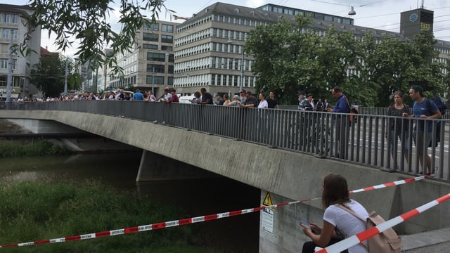 Schaulustige auf einer Brücke schauen auf den Fluss. Schaulustige auf einer Brücke schauen auf den Fluss.