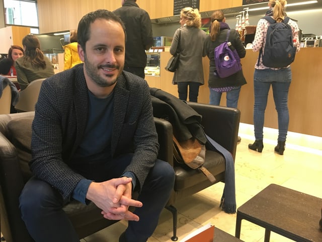 Ein Mann sitzt in einem Sofastuhl. Ein Mann sitzt in einem Sofastuhl.