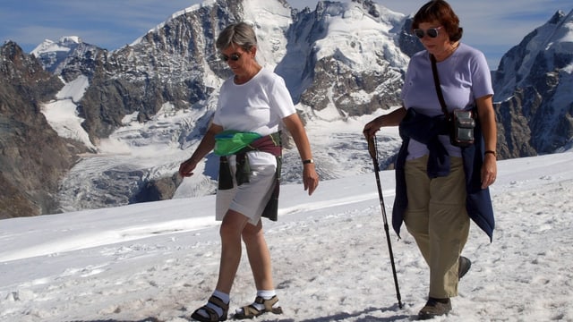 Zwei ältere Frauen auf Schnee gehend Zwei ältere Frauen auf Schnee gehend