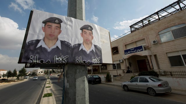 Ein Doppelplakat mit dem Gesicht des entführten jordanischen Piloten in einer Strasse in Ammann. Ein Doppelplakat mit dem Gesicht des entführten jordanischen Piloten in einer Strasse in Ammann.