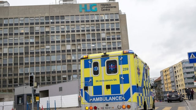 Eine Ambulanz fährt am Hauptgebäude des Universitätsspital Genf vorbei. Eine Ambulanz fährt am Hauptgebäude des Universitätsspital Genf vorbei.
