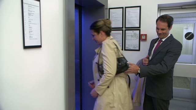 Ein Mann lässt eine Frau vor ihm in den Lift steigen