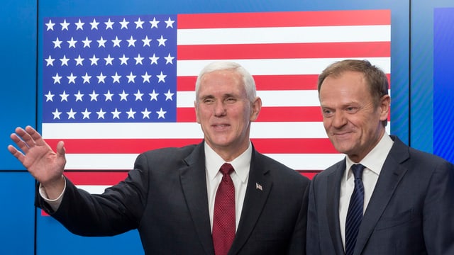 Pence und Tusk stehen vor einer US-Flagge.