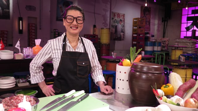 Eine Frau mit auffallender Brille und breitem Lachen blickt in die Kamera. Eine Frau mit auffallender Brille und breitem Lachen blickt in die Kamera.