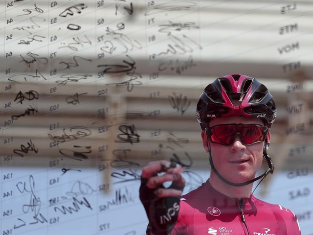Chris Froome unterschreibt auf einer Plexiglas-Wand Chris Froome unterschreibt auf einer Plexiglas-Wand