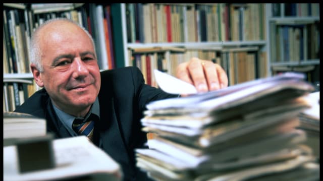 Jean-Christophe Ammann hinter einem Stapel Zeitschriften. Jean-Christophe Ammann hinter einem Stapel Zeitschriften.