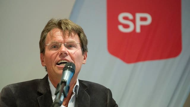 Ein Mann spricht in ein Mikrofon. Ein Mann spricht in ein Mikrofon.