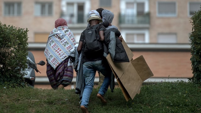 Flüchtlinge gehen über Wiese Flüchtlinge gehen über Wiese