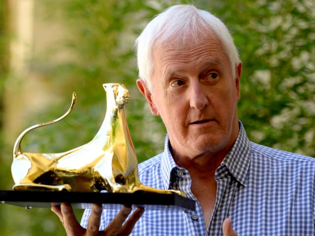 Mann hält eine goldene Trophäe in der Hand. Mann hält eine goldene Trophäe in der Hand.