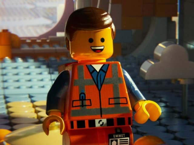 Ein Legomännchen mit scheitelfrisur und orange-farbener Arbeiterkluft. Ein Legomännchen mit scheitelfrisur und orange-farbener Arbeiterkluft.
