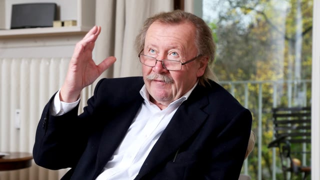 Mann sitzt in einem Stuhl und zeigt nach oben. Mann sitzt in einem Stuhl und zeigt nach oben.