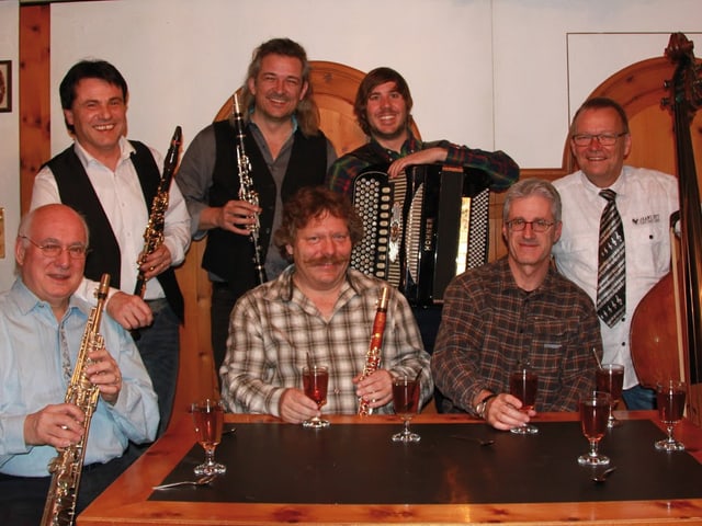 Gruppenfoto mit stehenden und sitzenden Musikern. Gruppenfoto mit stehenden und sitzenden Musikern.