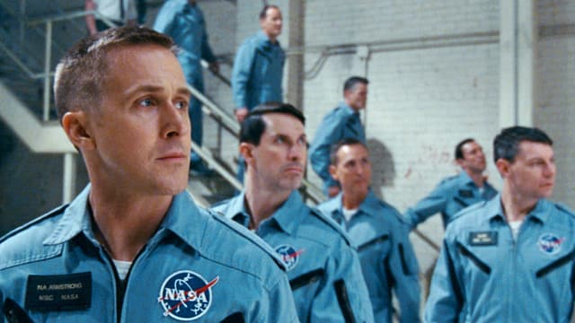 Männer in NASA anzügen laufen eine Treppe hinunter (Filmstil «First Man»). Männer in NASA anzügen laufen eine Treppe hinunter (Filmstil «First Man»).