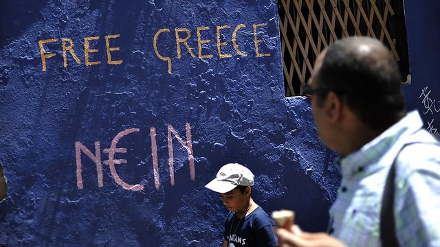 Menschen vor einem Graffiti in Athen
