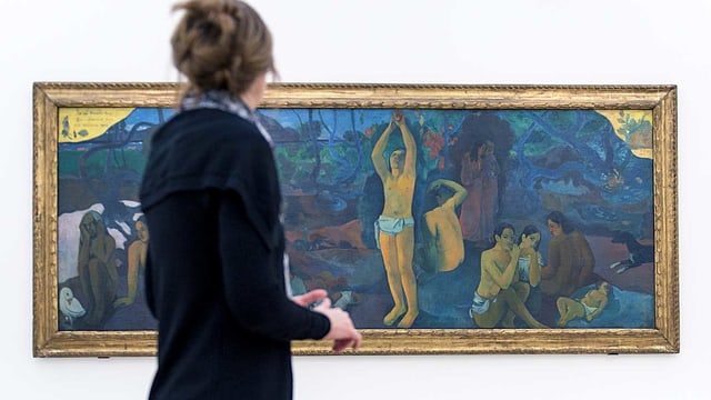 Eine Frau vor einem Gauguin-Gemälde. Eine Frau vor einem Gauguin-Gemälde.