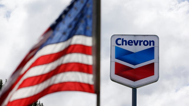 Das Chevron-Logo neben der USA-Flagge. Das Chevron-Logo neben der USA-Flagge.