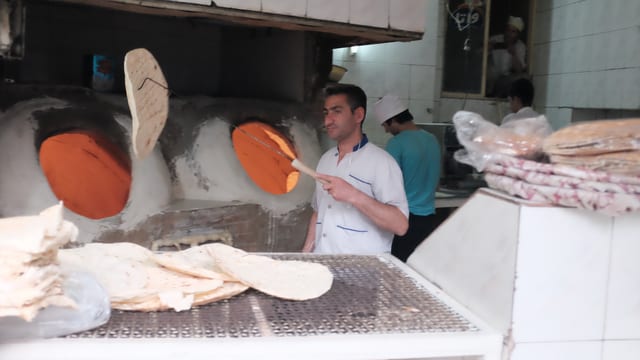 Ein Mann, der Fladenbrot schwingt. Ein Mann, der Fladenbrot schwingt.
