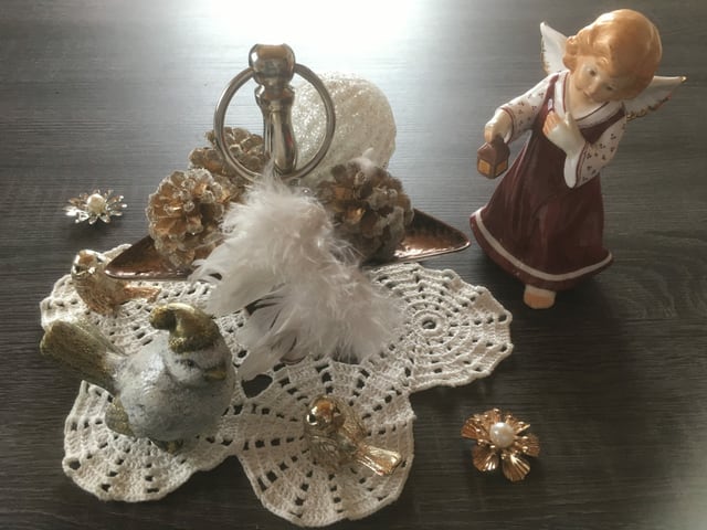 Engel aus Porzellan neben Zierdecke und Vögeln.