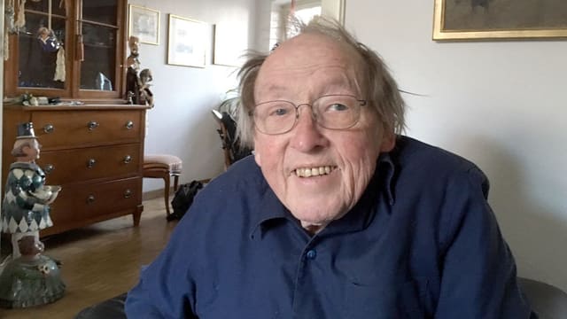 Ein älterer Mann in blauem Hemd schaut lachend in die Kamera Ein älterer Mann in blauem Hemd schaut lachend in die Kamera
