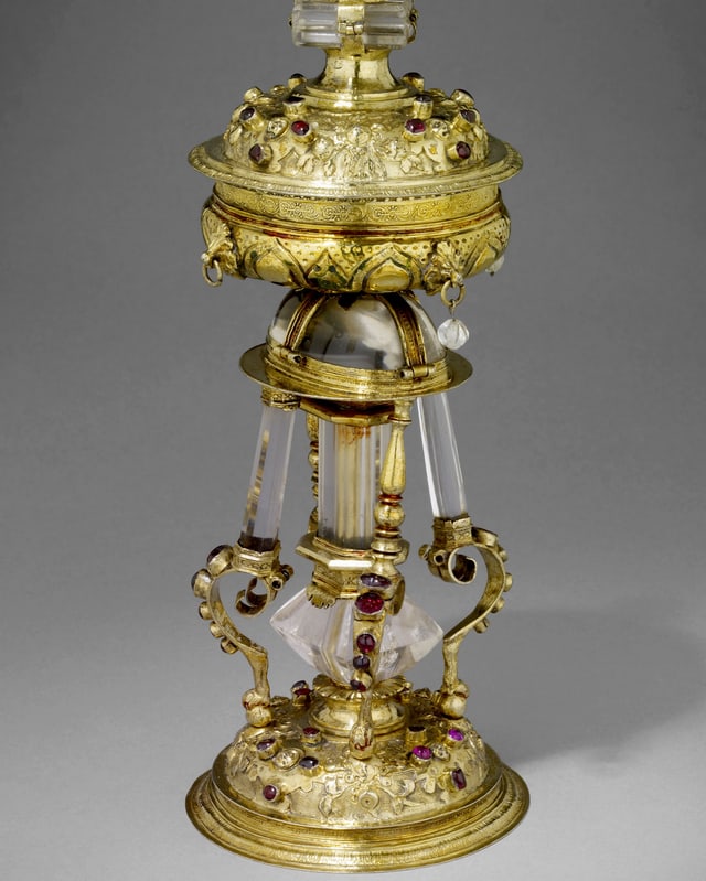 Ein goldener Salzstreuer, der mit roten und blauen Steinen besetzt ist. Ein goldener Salzstreuer, der mit roten und blauen Steinen besetzt ist.