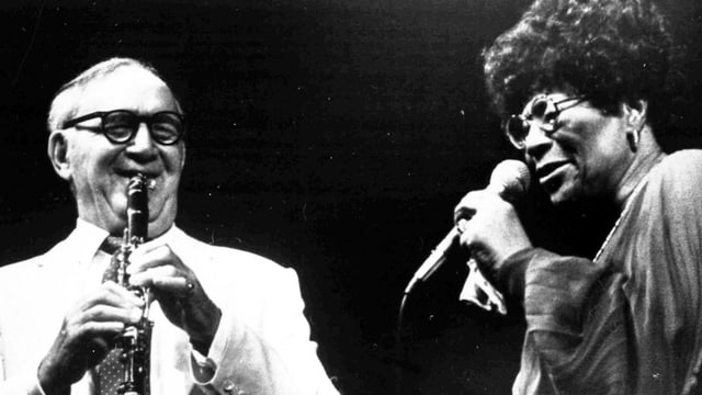 Man sieht Benny Goodman zusammen mit Ella Fitzgerald bei einem Auftritt. Man sieht Benny Goodman zusammen mit Ella Fitzgerald bei einem Auftritt.