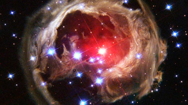 Aufnahme des Hubble-Teleskopfs mit einem Galaxienebel und diversen Sternen.