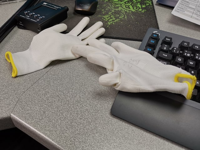 Ein paar weisse Handschuhe.