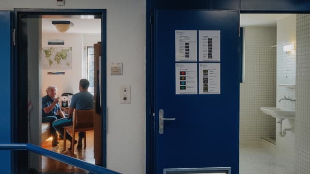 Blick von aussen in ein Zimmer, in dem zwei Männer sitzen und Kaffe trinken. Blick von aussen in ein Zimmer, in dem zwei Männer sitzen und Kaffe trinken.
