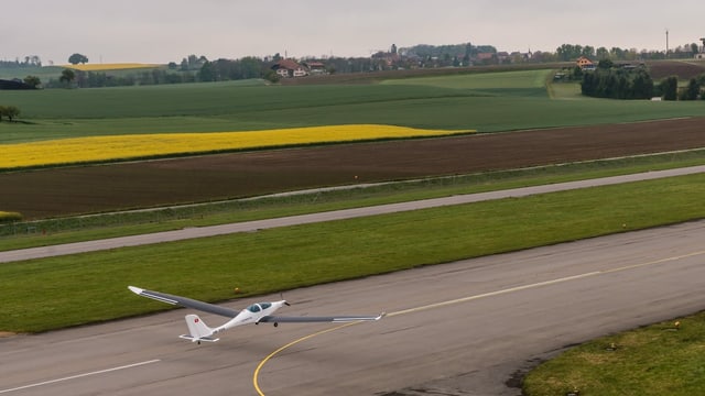 Ein Flugzeug mit Solarpanels auf den Flügeln beim Start auf einem ländlichen Schweizer Flughafen. Ein Flugzeug mit Solarpanels auf den Flügeln beim Start auf einem ländlichen Schweizer Flughafen.