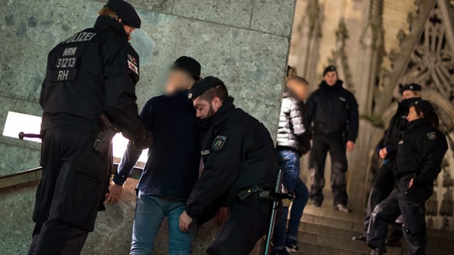Polizisten überprüfen Verdächtige am Kölner Hauptbahnhof
