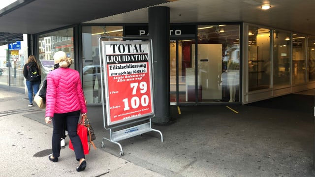 Schild "Totalliquidation" vor Laden. Schild "Totalliquidation" vor Laden.