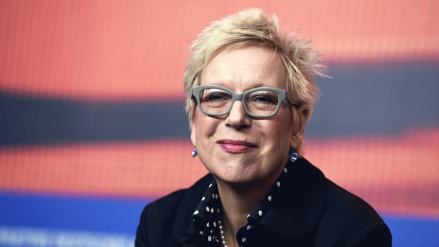 Eine Frau mit kurzen Haaren und Brille lächelt in die Kamera. Eine Frau mit kurzen Haaren und Brille lächelt in die Kamera.