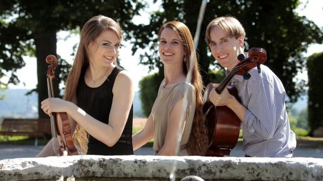 Trio sitzt an Brunnen. Trio sitzt an Brunnen.