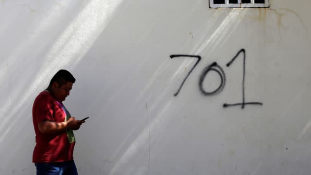 Symbolbild mit einem Mann am rechten Bildrand in roter Jacke, der an einer weissen Mauer mit der Aufschrift «701» vorbeigeht. 701 - das war Guzmáns Platz auf der Liste der reichsten Menschen des US-Magazins «Forbes». Symbolbild mit einem Mann am rechten Bildrand in roter Jacke, der an einer weissen Mauer mit der Aufschrift «701» vorbeigeht. 701 - das war Guzmáns Platz auf der Liste der reichsten Menschen des US-Magazins «Forbes».