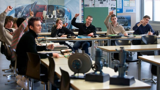 Schüler in Schulzimmer strecken Hände auf Schüler in Schulzimmer strecken Hände auf