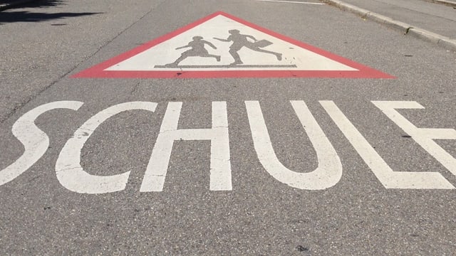 Strasse mit Aufschrift Schule und Zeichen Schulhaus. Strasse mit Aufschrift Schule und Zeichen Schulhaus.