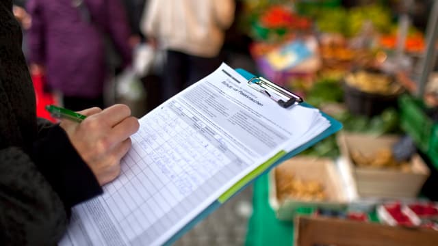 Person füllt Unterschriftenbogen aus Person füllt Unterschriftenbogen aus