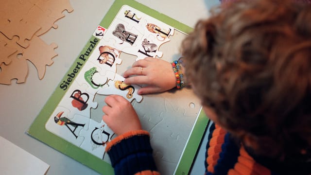 Ein Kind löst ein Puzzel Ein Kind löst ein Puzzel