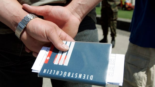 Ein Soldat hält sein Dienstbüchlein Ein Soldat hält sein Dienstbüchlein
