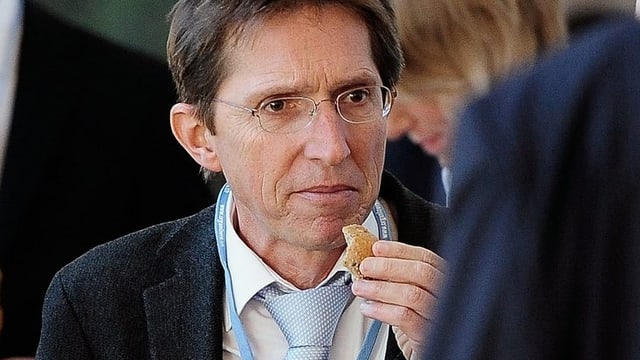 Michael Jordi, mit hellblauer Krawatte, beisst bei einem Apéro in ein Brötchen. Michael Jordi, mit hellblauer Krawatte, beisst bei einem Apéro in ein Brötchen.
