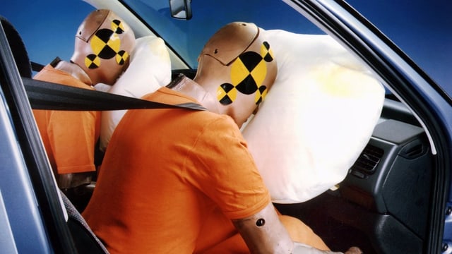 Dummies drücken Gesicht in aufgeblasenen Airbag. Dummies drücken Gesicht in aufgeblasenen Airbag.