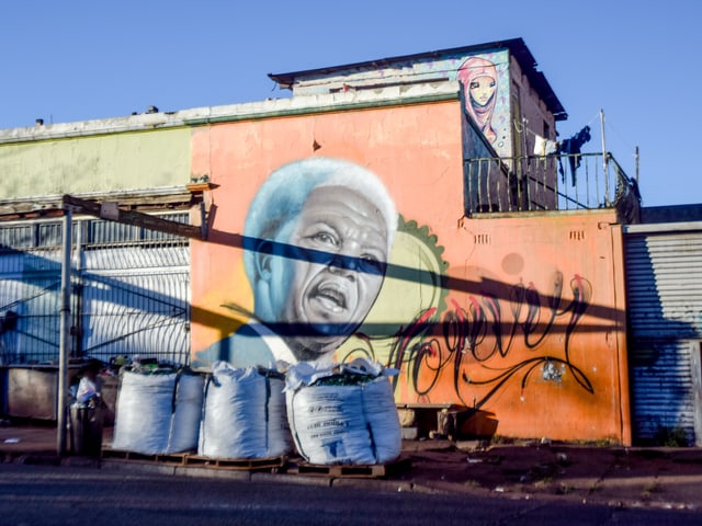Grafitto, das einen älteren Nelson Mandela zeigt, auf der Rückseite eines Hauses. Grafitto, das einen älteren Nelson Mandela zeigt, auf der Rückseite eines Hauses.