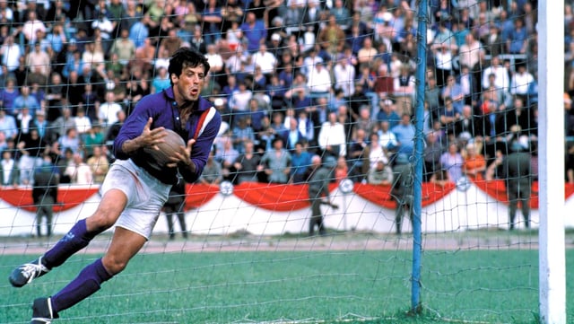 Sylvester Stallone steht im Tor und pariert einen Ball. Sylvester Stallone steht im Tor und pariert einen Ball.