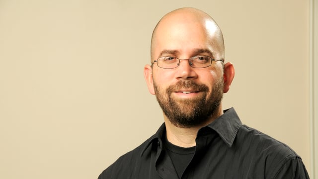 Porträt von Anthony Graesch mit Brille, Glatze und schwarzem Hemd. Porträt von Anthony Graesch mit Brille, Glatze und schwarzem Hemd.