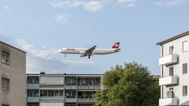 Ein Flugzeug überquert eine Wohnsiedlung. Ein Flugzeug überquert eine Wohnsiedlung.